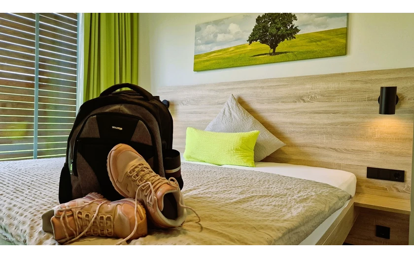 Zimmer im Hotel Fünf10 mit Wanderschuhen und Rucksack auf dem Bett