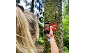 Smartphone & Rothaarsteig-Logo Wanderin fotografiert das Rothaarsteig-Logo mit einem Smartphone