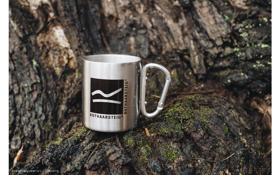Rothaarsteig Tasse aus Edelstahl steht auf einem Baumstumpf