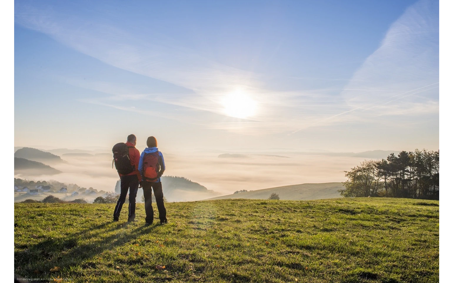 Zwei Rothaarsteig-Wandernde gucken bei Düdinghausen in den Sonnenaufgang