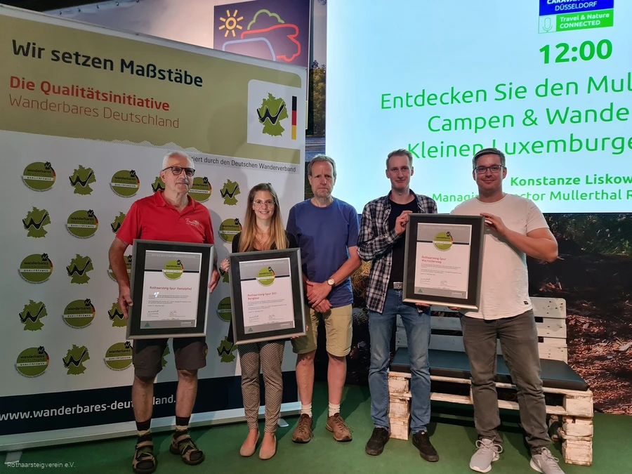 Gruppe auf einer B&uuml;hne mit Urkunden der zertifizierten Wege